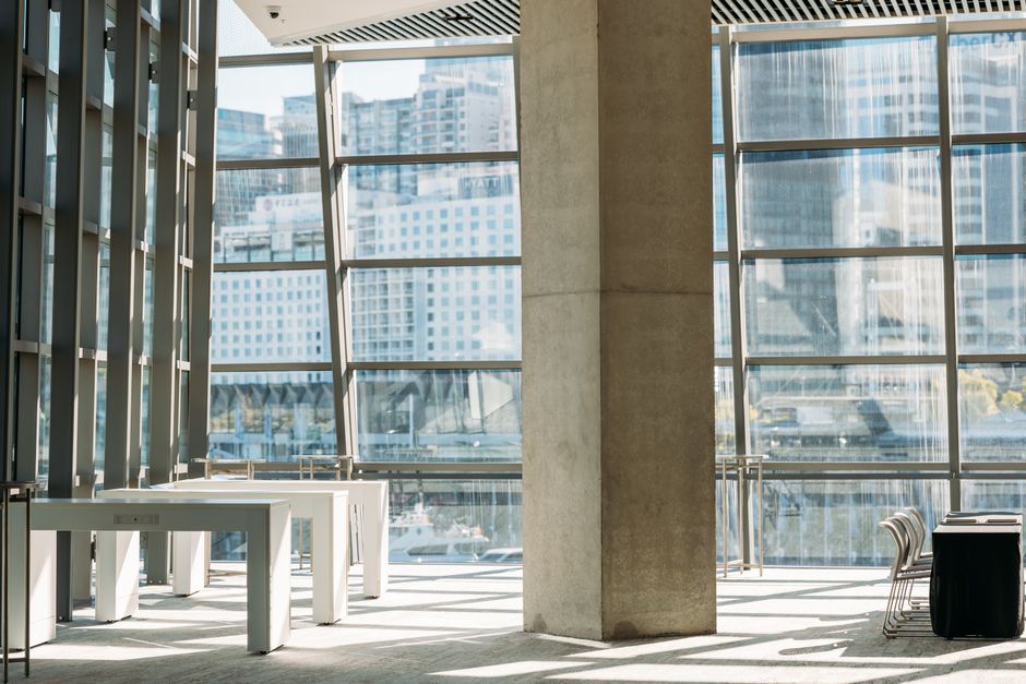 Bright conference area with large windows showcasing Sydney urban landscape.