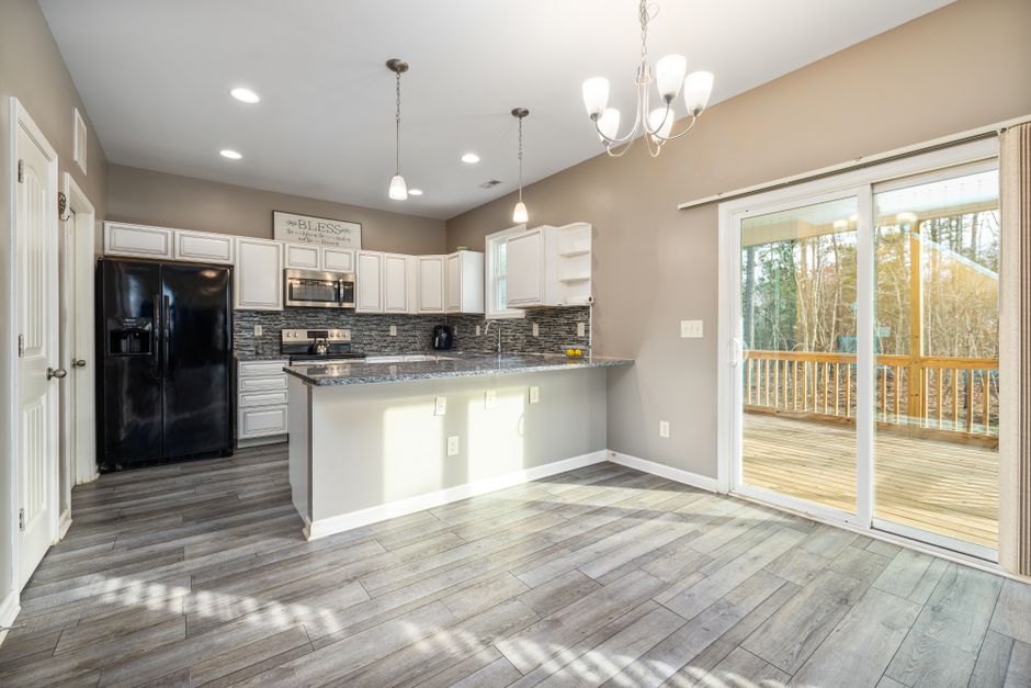 Spacious modern kitchen with island and sliding doors to a balcony, ideal for culinary enthusiasts.